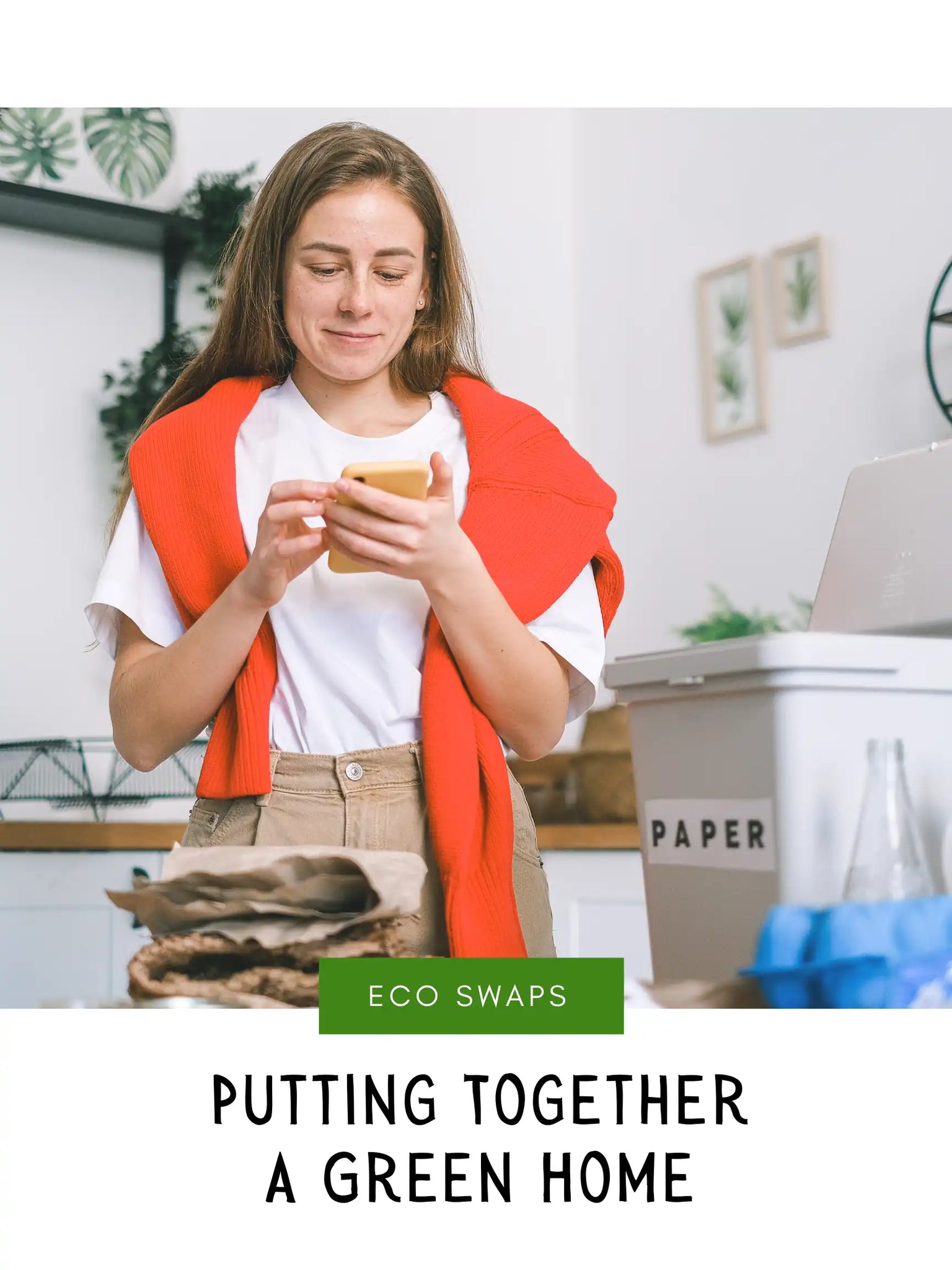 Smiling woman sorting waste and using smartphone in the kitchen