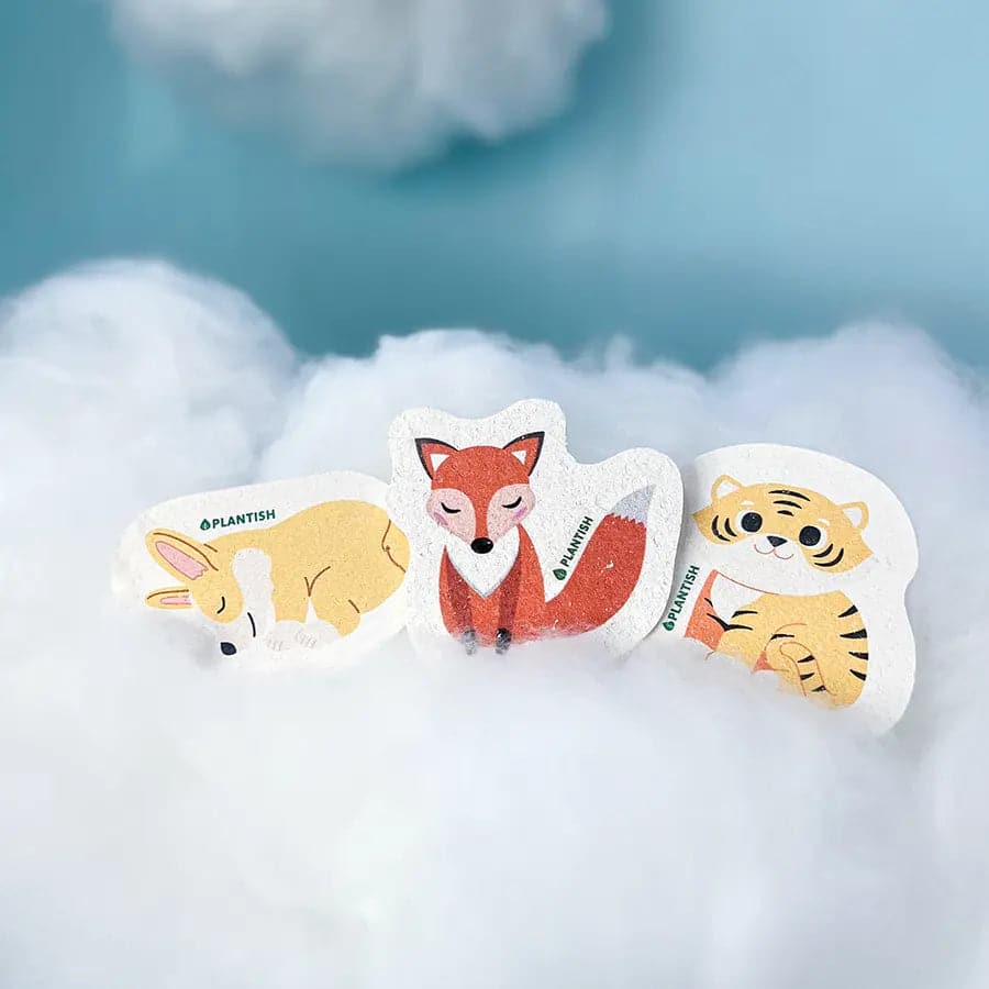 Three furry-themed pop-up sponges on a cloud for eco-friendly kitchen cleaning. Reusable, made of wood pulp for a plastic-free and compostable option.