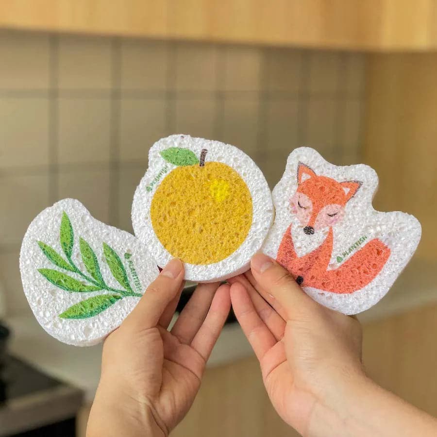 Hands holding a set of 3 bestselling pop-up sponges, perfect for zero waste cleaning. Made with wood pulp, these sponges are 100% biodegradable and compostable.