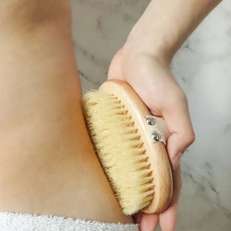 Using eco friendly and plastic free body brush on hips to exfoliate.