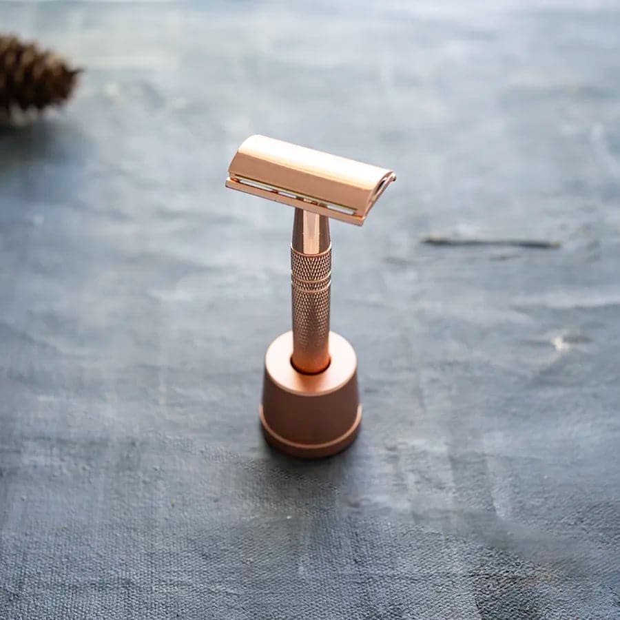 Plastic free and eco friendly rose gold reusable razor with matching holder and single blade.