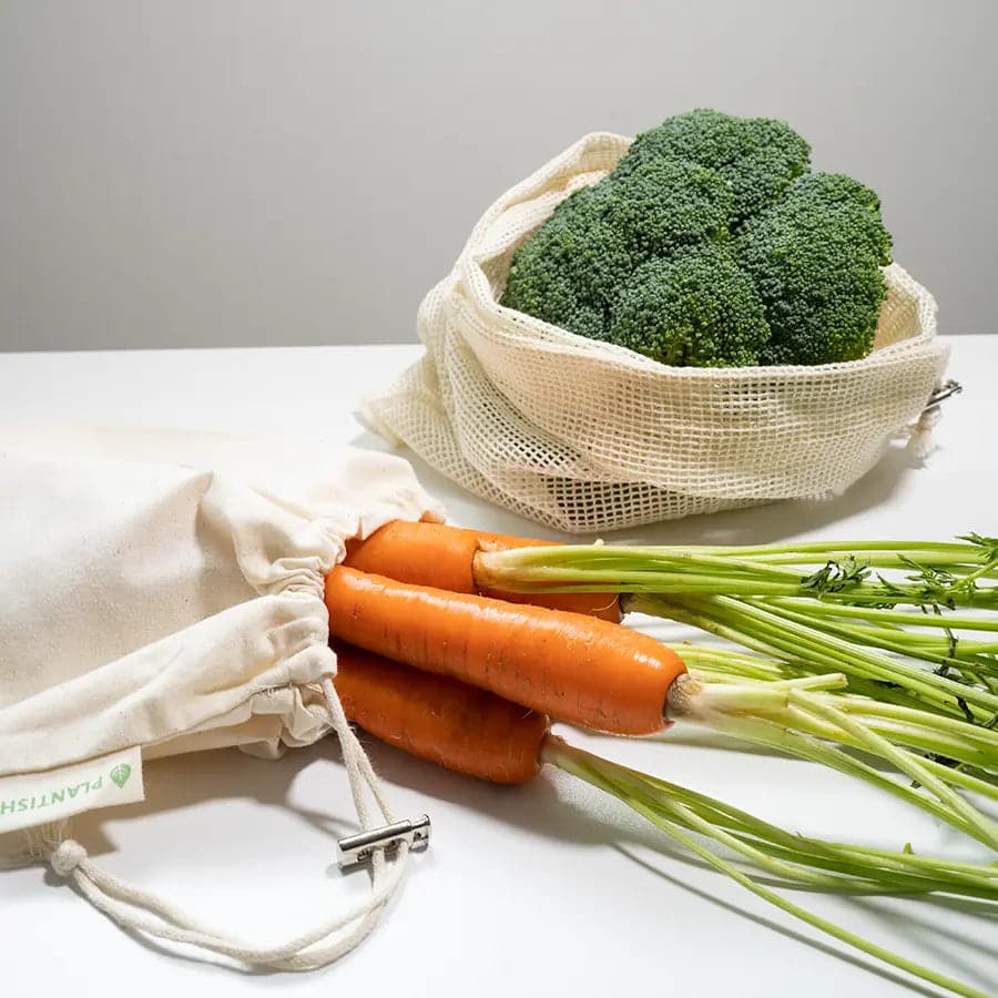 Carrots inside cotton muslin bags and broccoli inside organic cotton mesh bag.