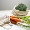 Carrots inside organic cotton muslin bag and broccoli inside organic cotton mesh bag.
