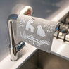 Plastic free reusable Swedish dishcloth hanging from the tap over the sink.