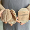Hands holding set of 2 loofah dishwashing sponges.