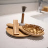Bamboo-based brush set on soap dish. Great eco friendly beauty essentials for your zero waste hair care routine.
