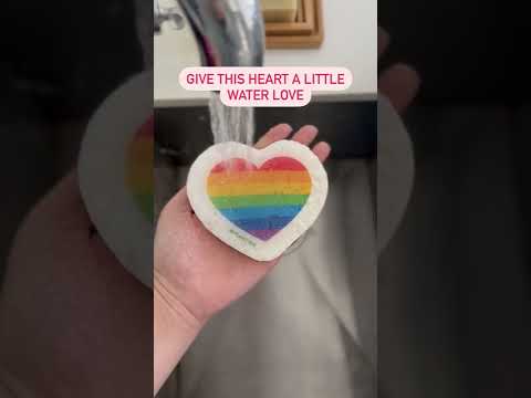 Video of a rainbow heart pop-up sponge running under water, expanding and transforming. Plastic-free and eco-friendly cleaning tool in action.