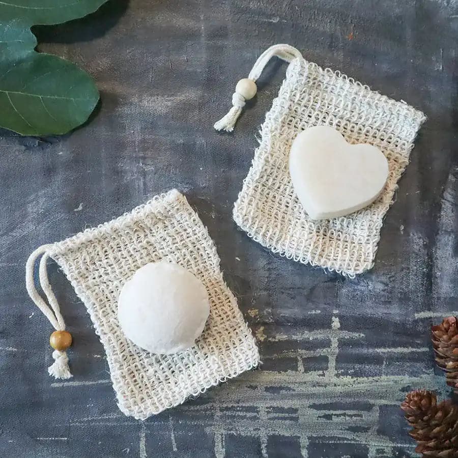 Hydrating shampoo and conditioner bar on top of loofah soap bags.