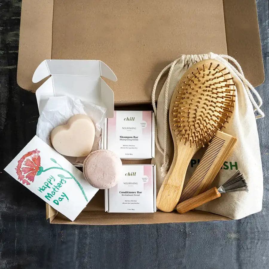 Set of bamboo brushes and nourishing shampoo and conditioner bar in zero waste packaging box.