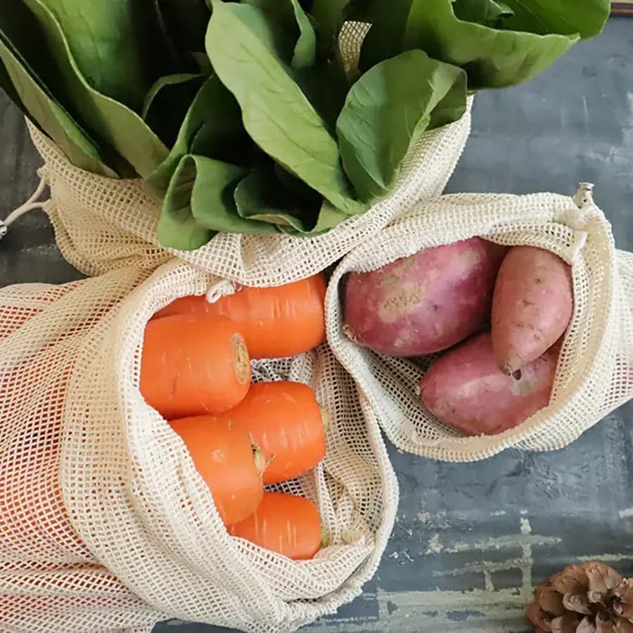 Fresh produce; carrots, radish and lettuce stored in organic cotton mesh bags.