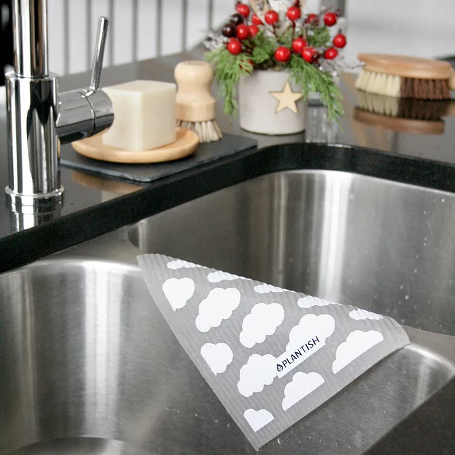Wet puffy taste reusable dish cloth hanging on sink.