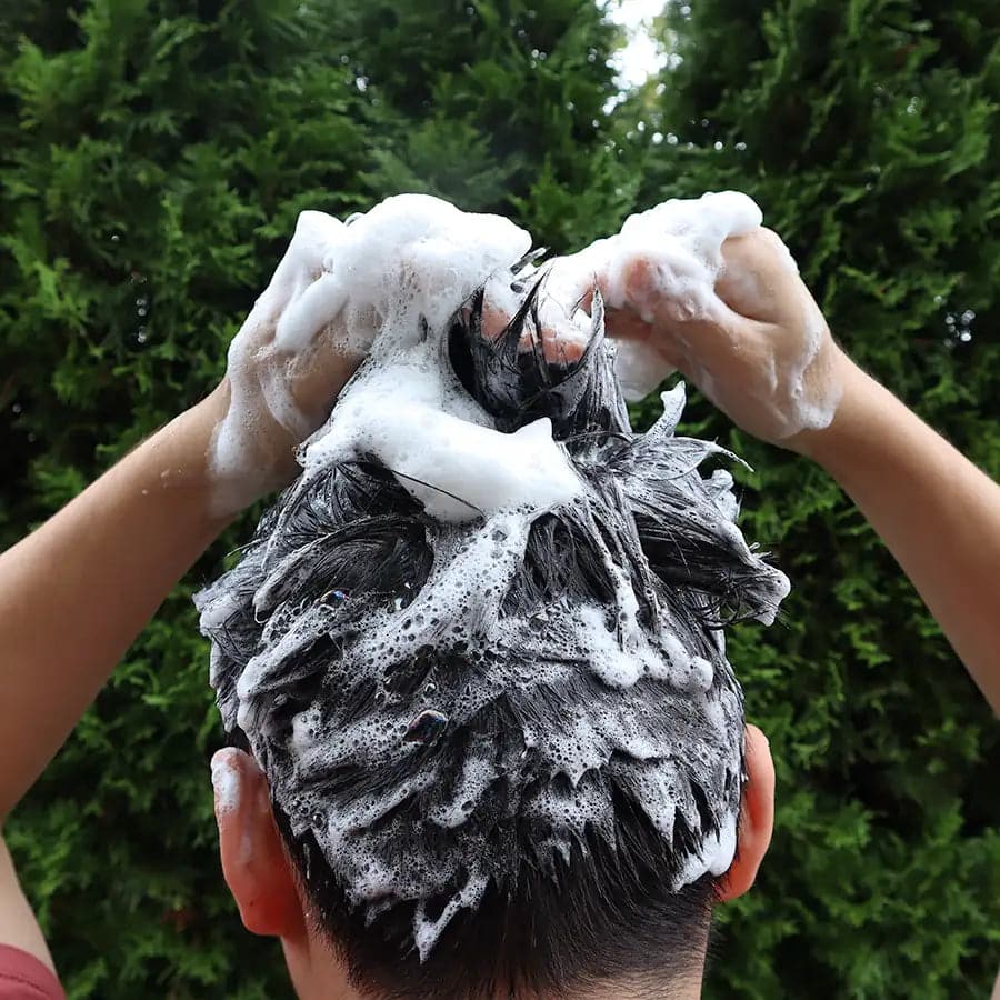 Lathering shampoo into hair.