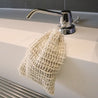 Loofah soap bag hanging on tap.