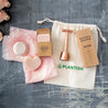 Nourishing shampoo and conditioner bar, rose and citrus full sized zero waste deodorant bar and rose gold double edge safety razor in organic cotton bag with drawstring.